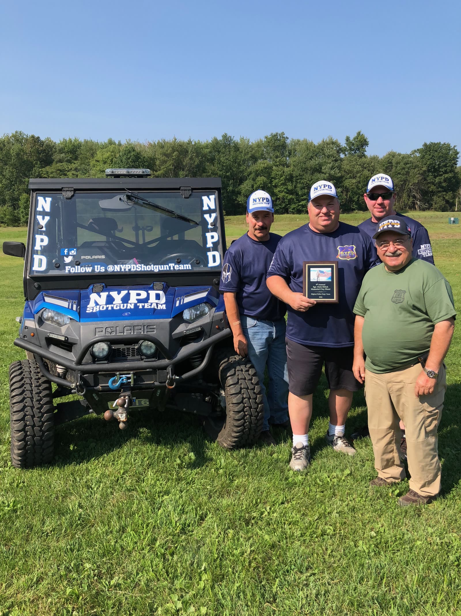 Mike and teammates beside a range UTV