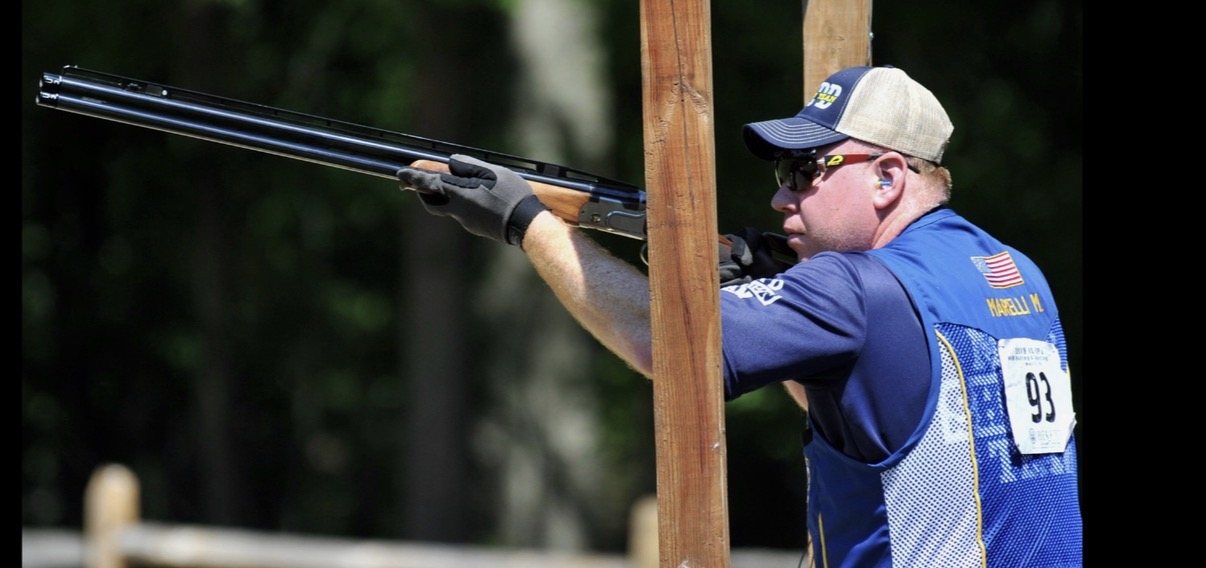 Mike Marelli aiming in an NYPD Shotgun Team competition vest, name MARELLI M. on the back